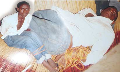 The victim lying on the bare floor inside the kitchen.